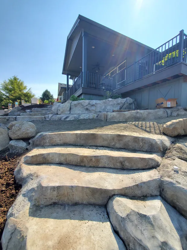 Hand-carved concrete steps and boulder walls at a modern home