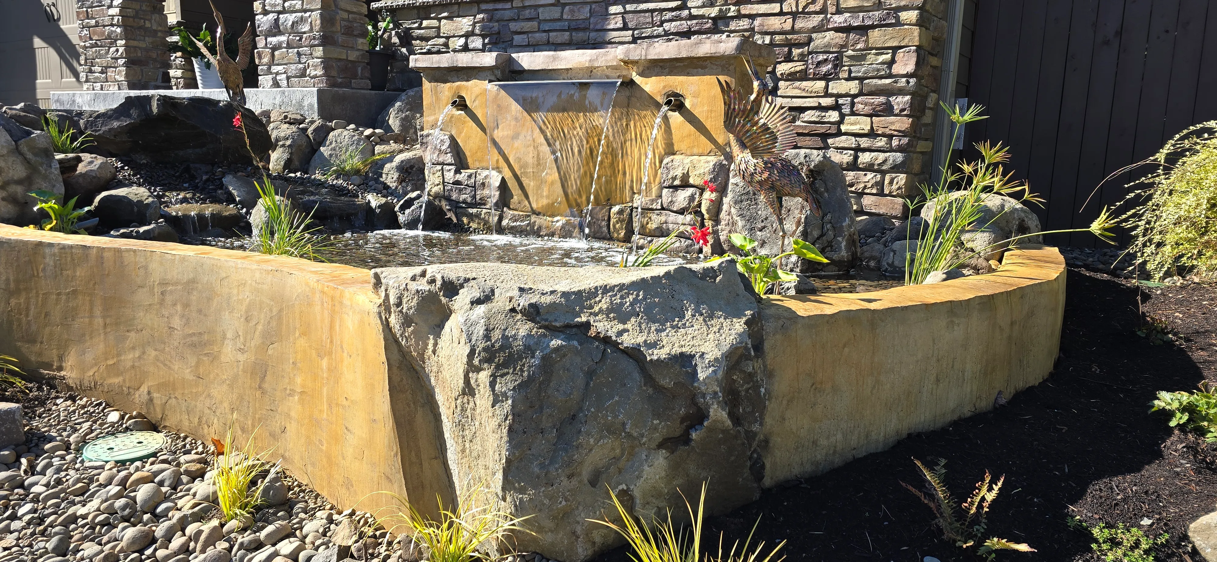 Carved basalt spillway fountain pouring into a patio pond in Canby, Oregon