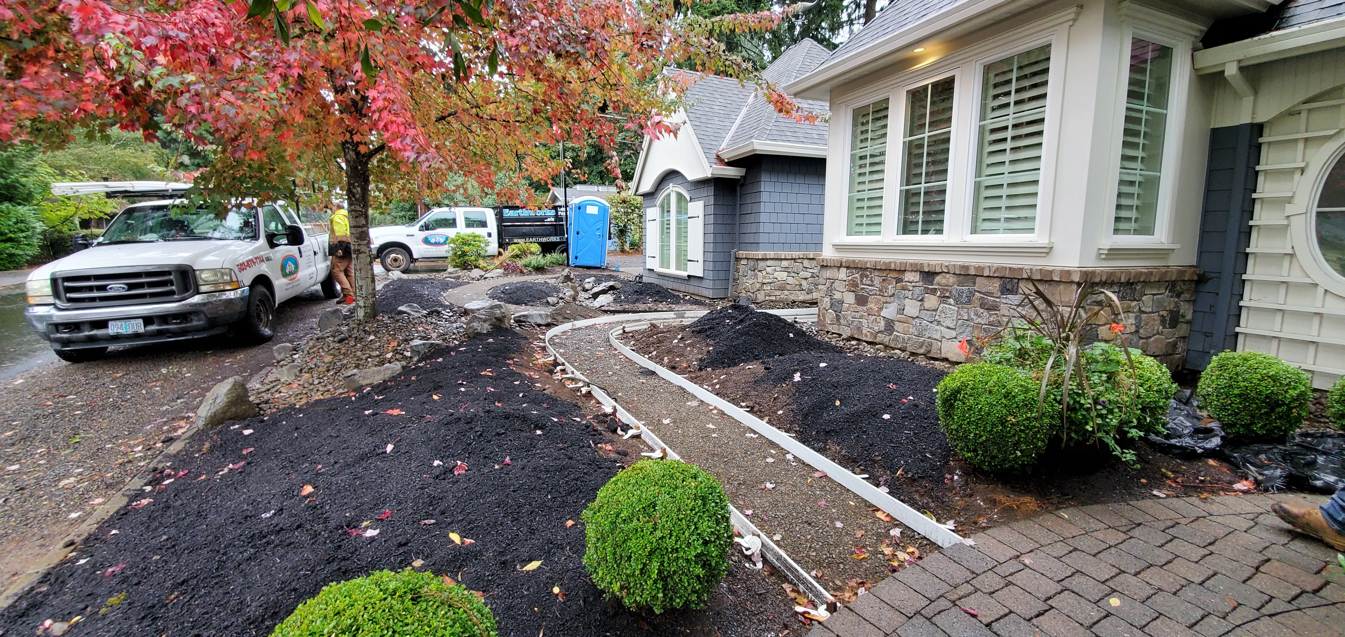 Fresh soil and a paver pathway taking shape across the stripped front yard
