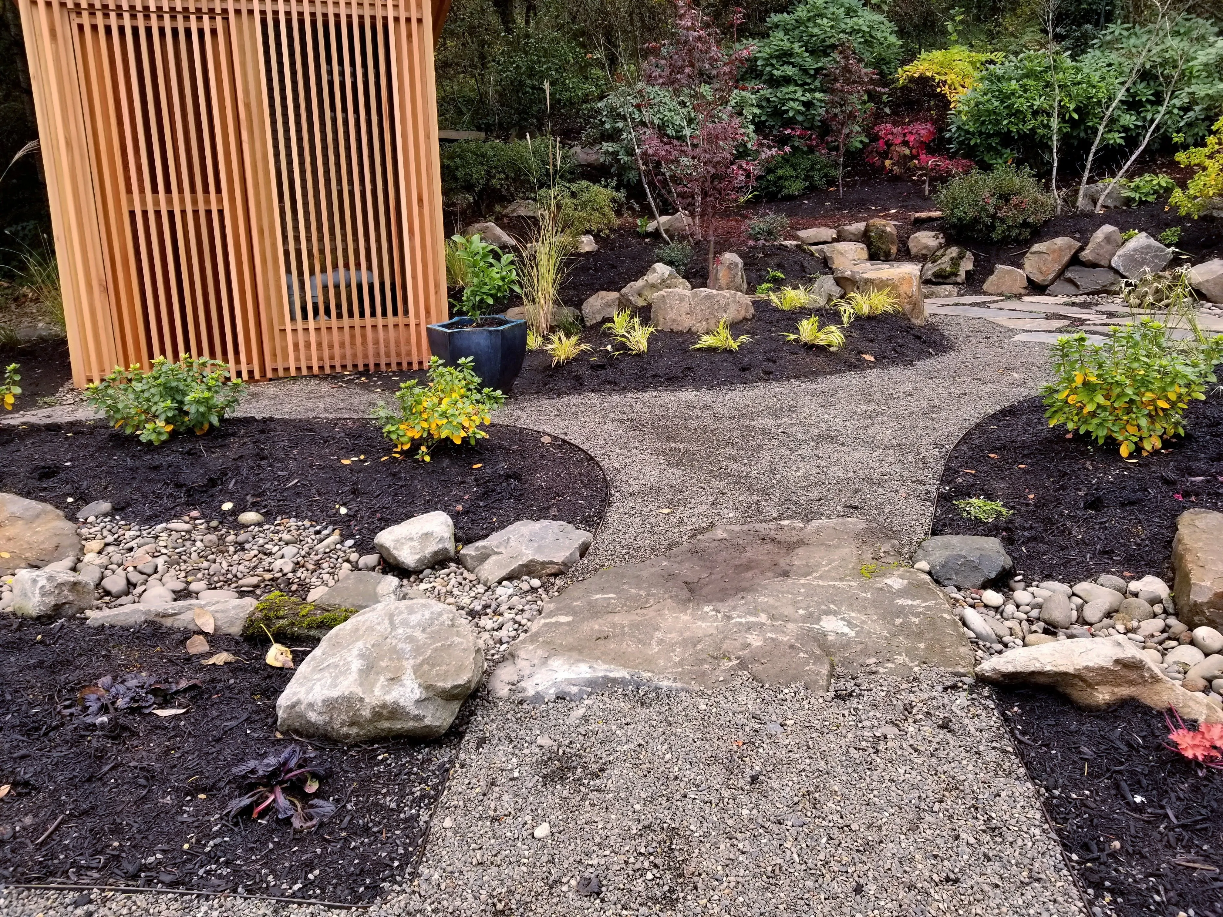 Dry creek bed and stepping stone path through autumn planting beds